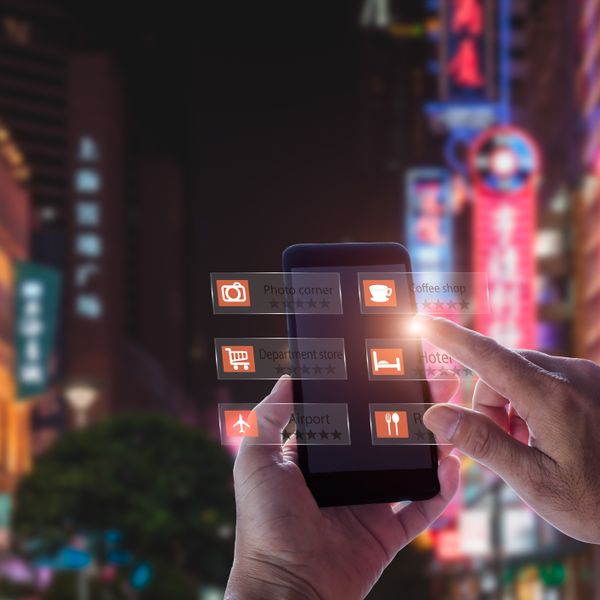 Hand holding smart phone using an AR application in the middle of a street at night