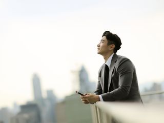 Businessman standing on city rooftop