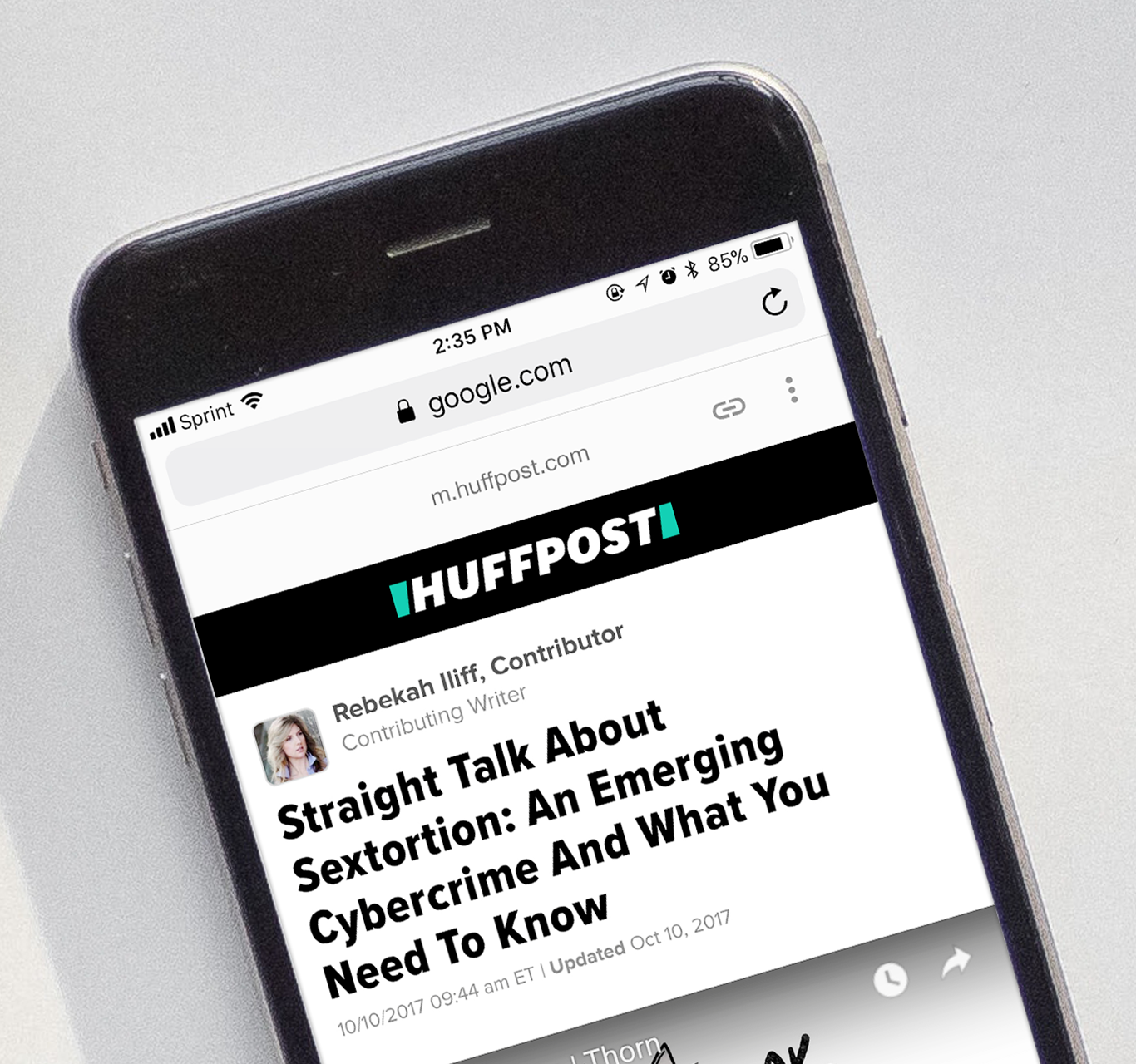 Smartphone with a Huffpost publication about sextortion on the screen