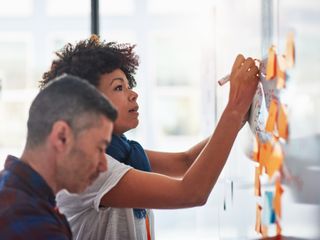 Woman and man brainstorming with sticky notes at an office