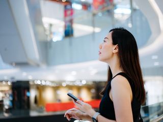 Woman using smartphone while shopping in a mall