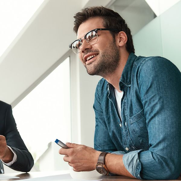 A trio of business individuals collaborating at a table within a professional office environment.