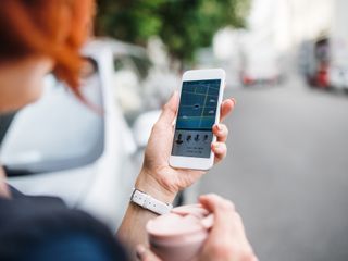 A woman looking at a ride sharing app on her phone