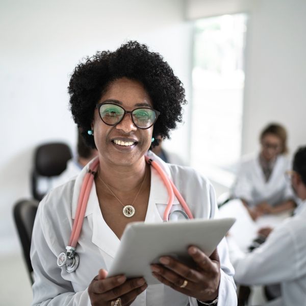 Female doctor using a digital tablet with doctor's meeting on background