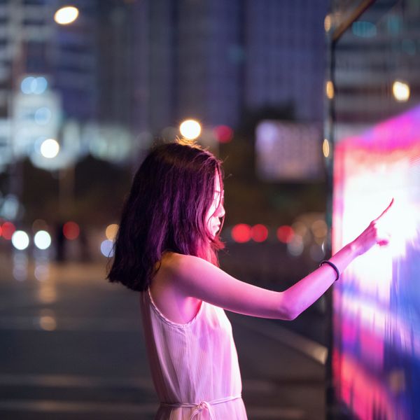 Woman using touch screen on the street